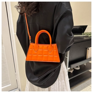 Gros plan sur un sac à main orange matelassé en cuir PU avec bandoulière réglable