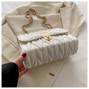 Detailed view of cream quilted chain bag with gold twist lock and elegant texture