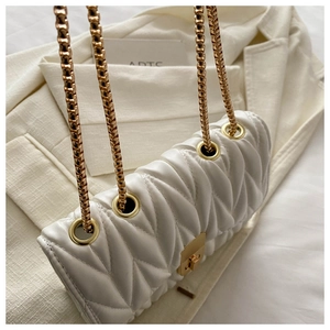 Close-up of white V-quilted shoulder bag with gold chain strap and metal turn-lock