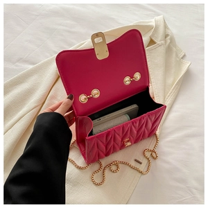Detailed interior of fuchsia quilted chain bag showing capacity for phone and wallet