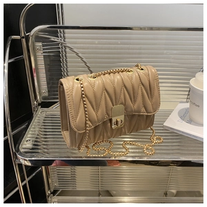 Close-up of beige quilted chain bag with gold metal twist lock and褶皱 texture