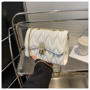 Detail of white quilted handbag with vertical pleats, gold metal lock and chain strap