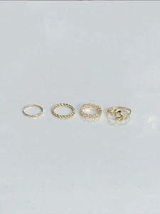 Detailed view of four-piece gold bohemian ring set with hollow star and olive leaf motifs
