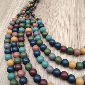 Handmade multilayer bohemian necklace with colorful matte wood beads on a rustic surface