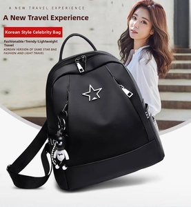 Detail of waterproof black Oxford backpack featuring a silver star and astronaut charm