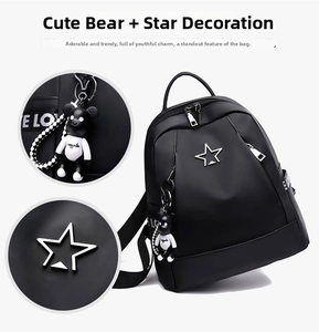Detail showing the black oxford backpack with a silver star and a cute bear pendant