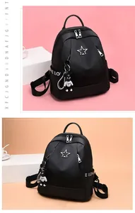 Detail of black oxford backpack with star logo, webbing strap and bear keychain
