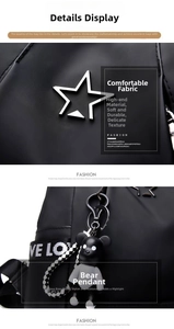 Detail of black nylon backpack featuring silver star logo and Bearbrick pendant
