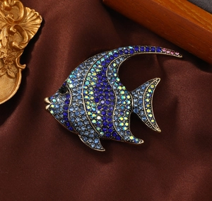 Vintage-Fischbrosche in Gold mit blauen und lila Strasssteinen auf braunem Satin