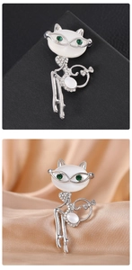 Detailed view of elegant silver cat brooch with large opal stone and green crystal eyes