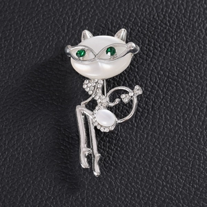 Sparkling cat-shaped brooch with white opal-like stone and green crystal eyes