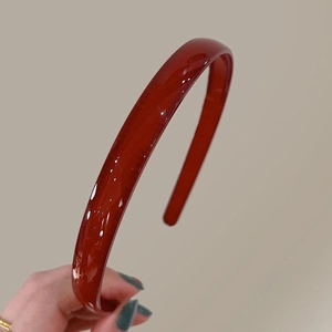 Détail d'un serre-tête fin bordeaux brillant avec dents antidérapantes pour la coiffure