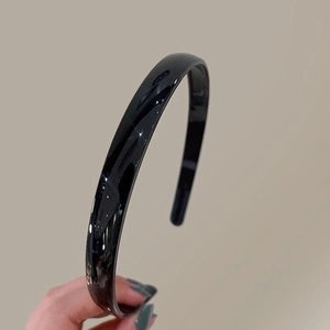 Vue détaillée de la surface brillante du serre-tête noir avec finition réfléchissante