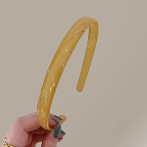 Détail d'un serre-tête jaune en résine brillante pour la coiffure quotidienne simple