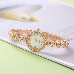 Detailed view of rose gold mermaid bracelet watch dial with sparkling crystals and leaf band