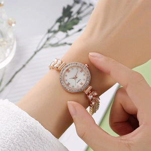 Close-up of rose gold mermaid watch featuring leaf-shaped crystal strap and rhinestone bezel