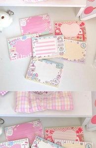 Close-up of cute cartoon cat notepad collection with pink peach and dessert illustrations