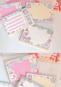 Close-up of cute cartoon cat memo pads with sweet pastel designs and tear-off pages