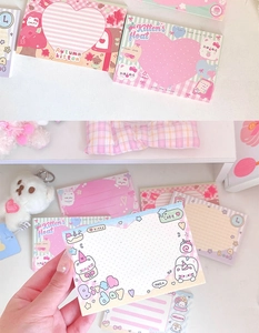 Detailed view of cute cat themed memo pads and postcards in pink and cream pastel tones