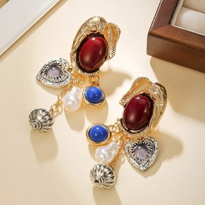 Detail of vintage Baroque earrings with faux pearls and reddish-brown oval gemstones