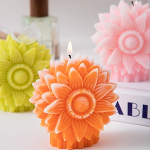 Three colorful sunflower shaped scented candles with layered petals in a cozy home setting