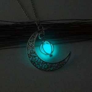 Luminous crescent moon necklace with teal glow pendant and silver filigree detail
