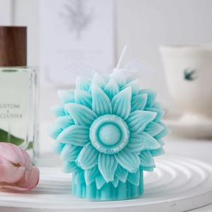 Detailed view of a light blue sunflower scented candle with a white silk ribbon bow