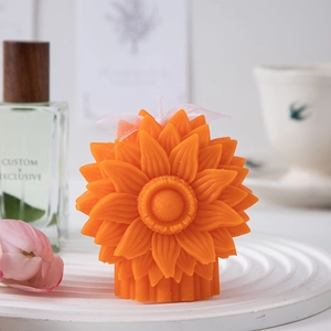 Detailed macro view of orange sunflower candle with delicate petals and gift ribbon