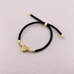 Adjustable black woven rope bracelet with polished 18k gold heart pendant for women
