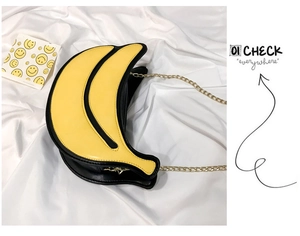 Detailed view of banana-shaped shoulder bag with yellow PU leather and gold chain