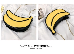Detail view of a creative banana-shaped crossbody bag with gold chain and black edging