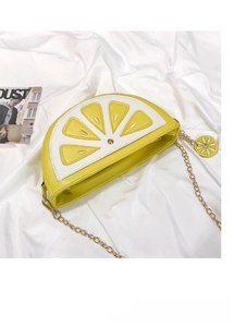 Detail of lemon slice crossbody bag with matte yellow PU leather and golden chain strap