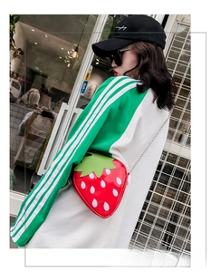 Detail shot of a creative strawberry-shaped crossbody bag with glossy PU and metal chain