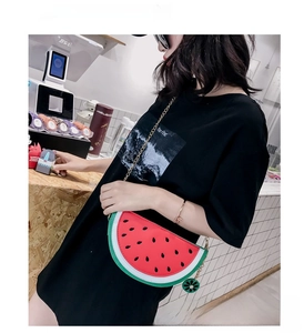 Detail of watermelon-shaped crossbody bag featuring vibrant colors and a gold chain strap