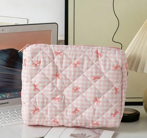 Detail of pink plaid quilted makeup bag featuring sweet bow patterns and soft fabric