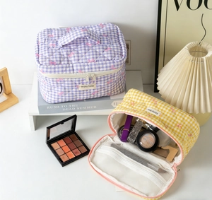 Quilted cosmetic bags in purple and yellow with bow patterns and internal storage mesh