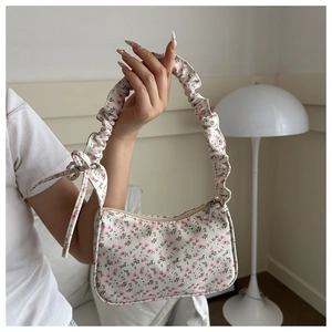 Detail of ruched handle and side bow knot on the floral print underarm bag
