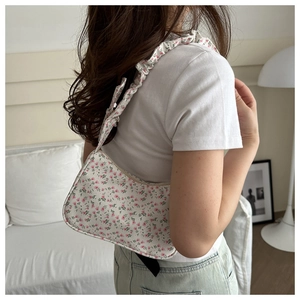 Floral print shoulder bag with retro pleated strap shown in a lifestyle interior