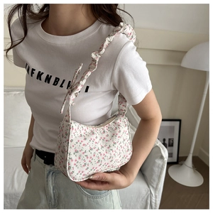 Detailed shot of floral shoulder bag with ruched strap and bow detail for women