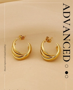 Detailed view of layered gold-plated C-shaped earrings with triple wave texture design