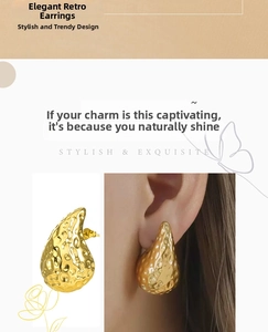 Detail of golden teardrop earrings featuring a unique hammered metal texture and design