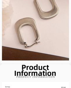 Macro detail of U-shaped silver metal earrings featuring a fine radial striped texture