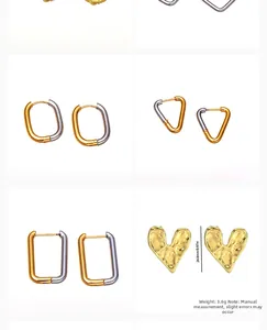 Detail of gold and silver heart-shaped earrings with textured hammered finish detail