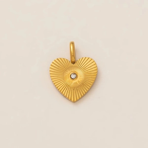 Macro shot of 18k gold plated heart pendant with sunburst texture and center crystal