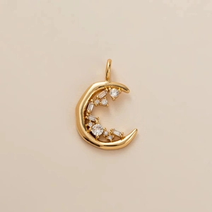 Detailed close-up of a crescent moon gold pendant with sparkling inlaid crystals