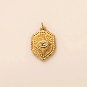 Detailed macro view of gold-plated stainless steel shield pendant with evil eye engraving
