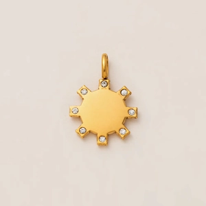 Detailed close-up of golden sunburst pendant with eight sparkling cubic zirconia stones