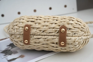Makro-Detail der handgewebten Strohtasche mit Lederverstärkung und Metallnieten
