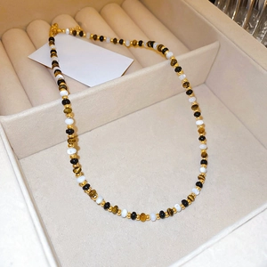 Beaded tiger eye stone necklace with black and gold beads in a soft jewelry box