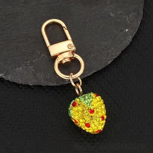 Handmade strawberry keychain featuring gold plating and glittering yellow rhinestones